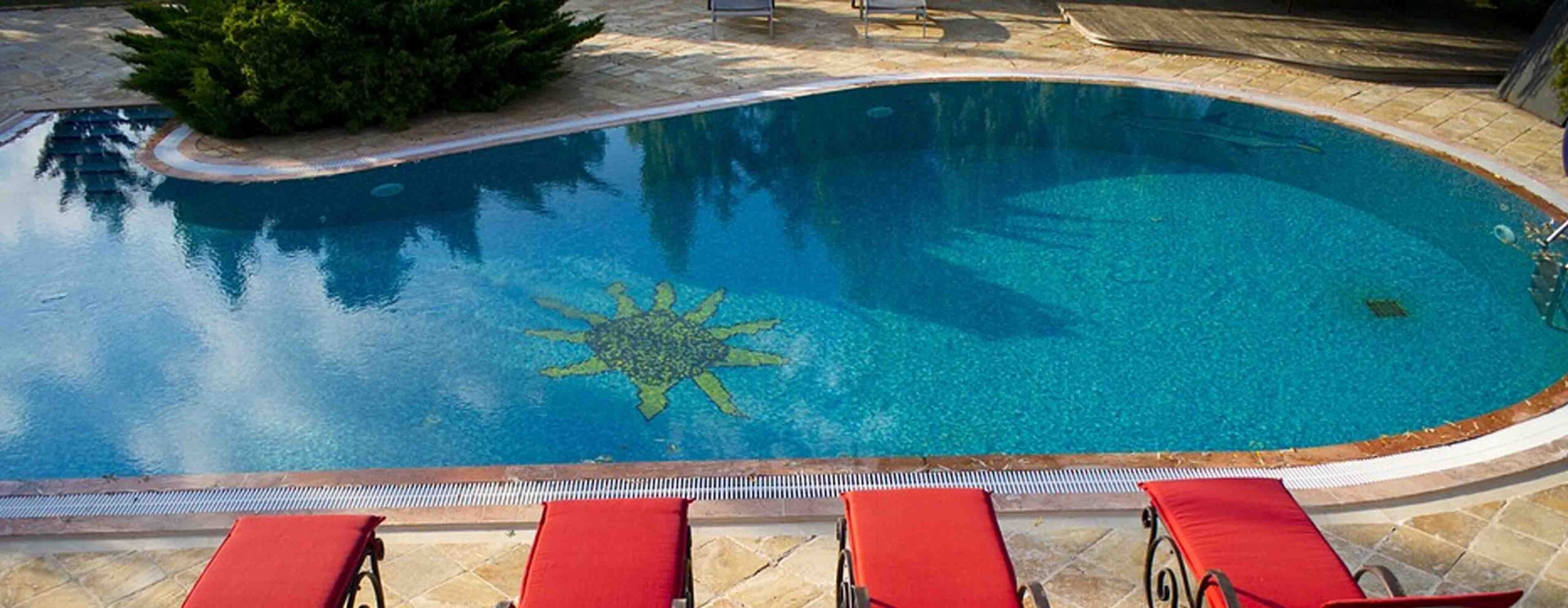 a swimming pool with lounge chairs around it.